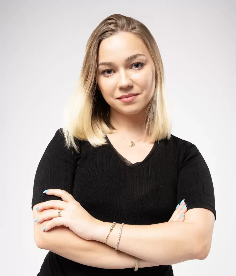 Alina Oțelea, în ținută neagră, cu brațele încrucișate, pe fundal deschis