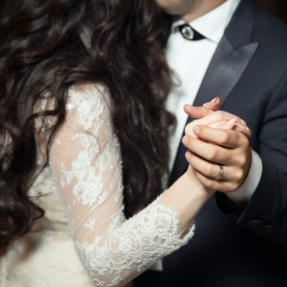 Close-up of the bride and groom’s joined hands during the dance